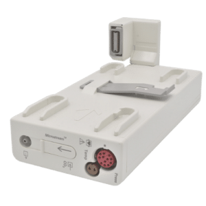 A white medical monitor module with multiple connectors and ports, an attached handle, and a silver clip on top. It has various symbols and labels on its body, indicating its functions and connections.